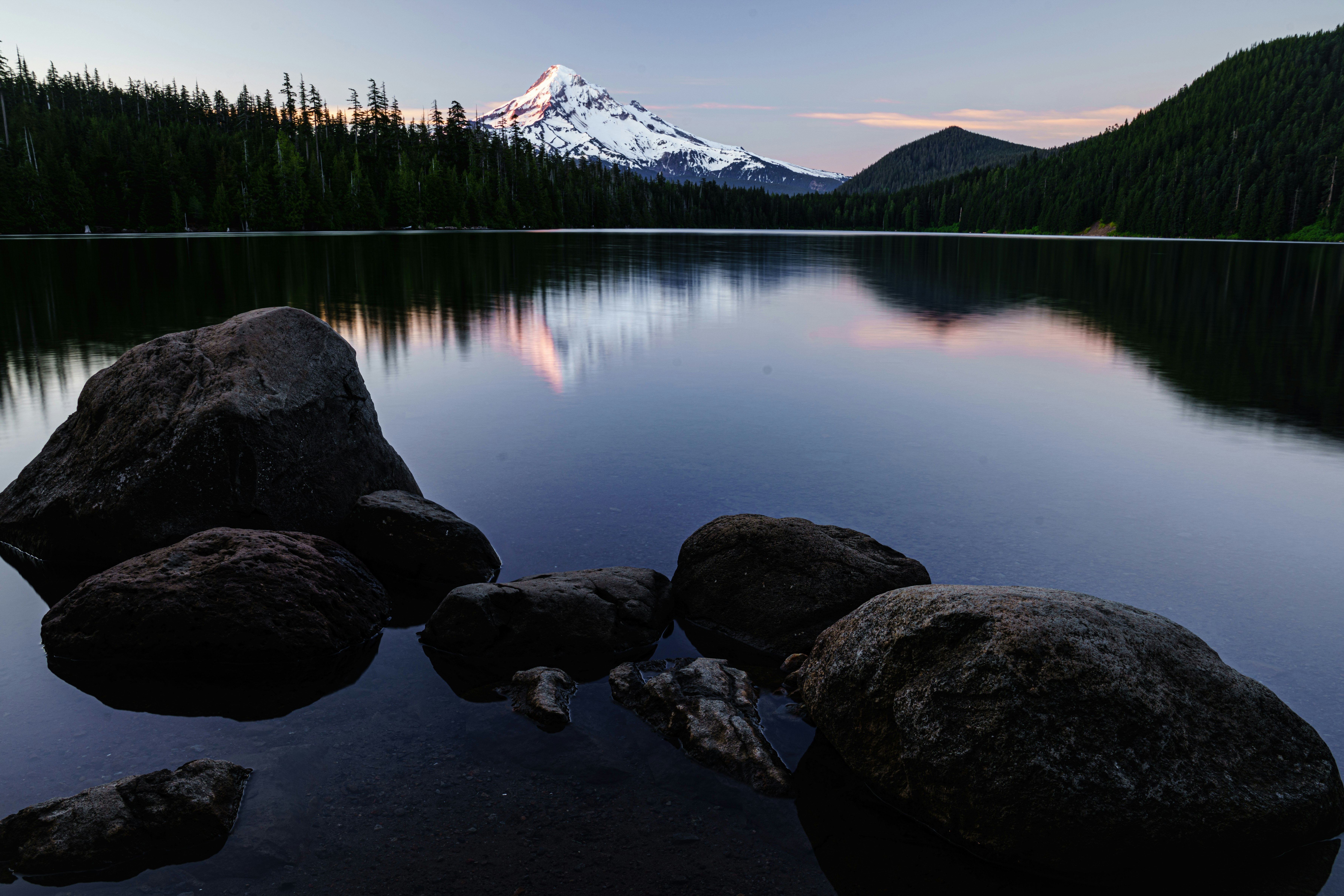 lake near trees and mountain during daytime